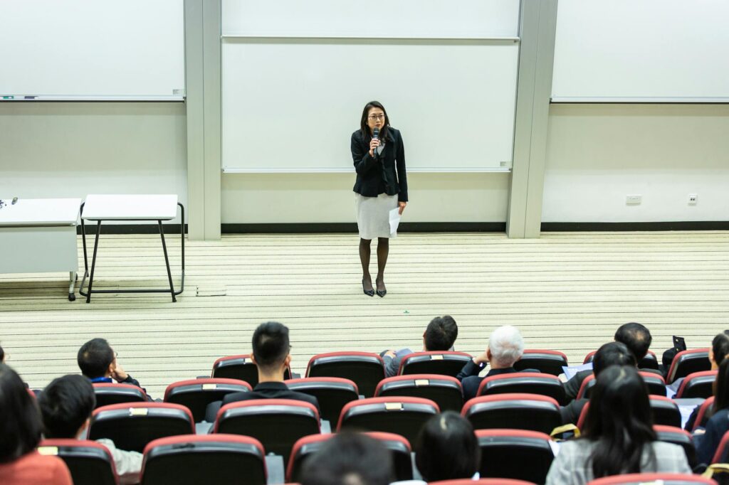 woman holding microphone standing in front of crowd